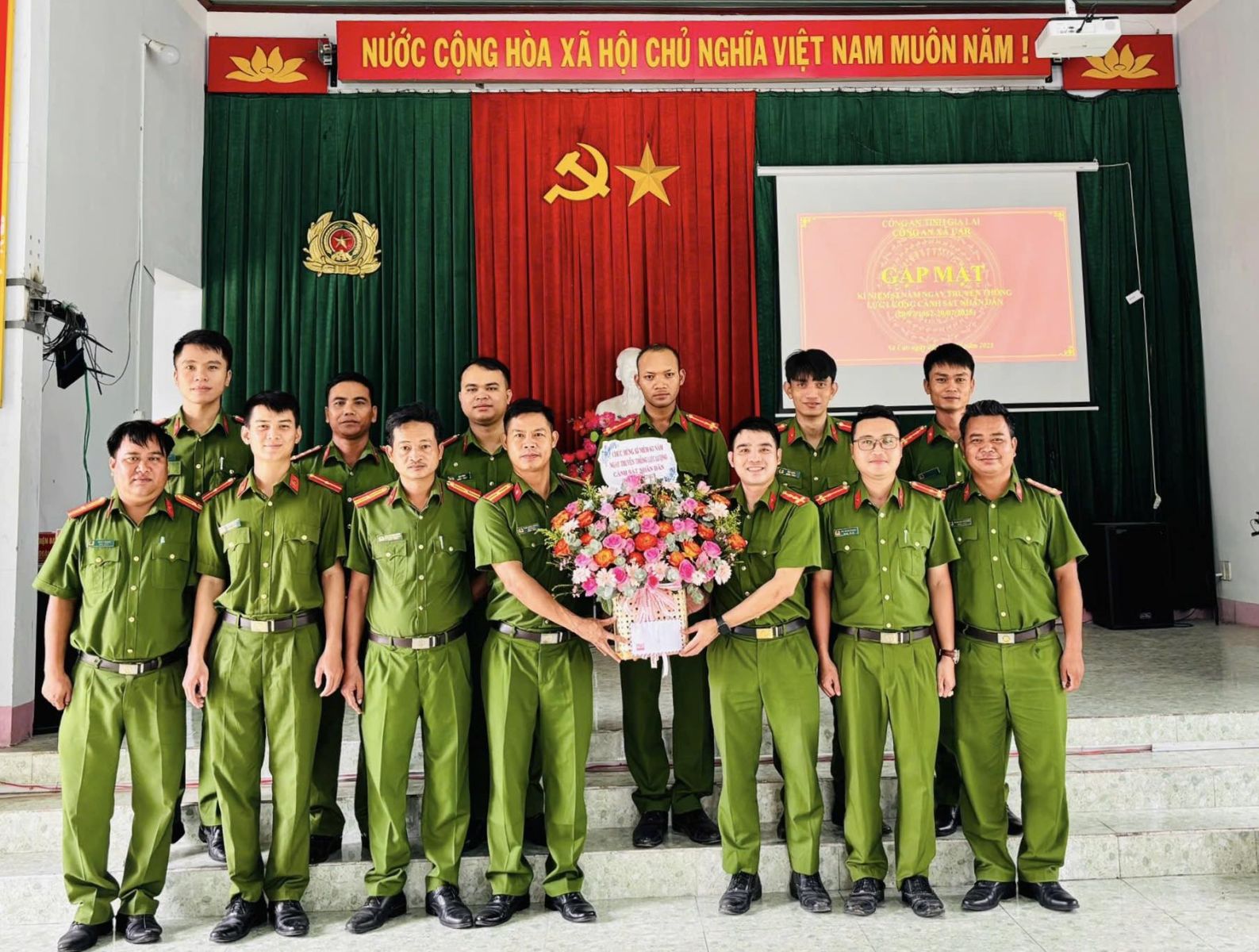 Đồng chí Thiếu tá Trần Xuân Hoàng - Trưởng Công an xã trao hoa chúc mừng lực lượng CSND